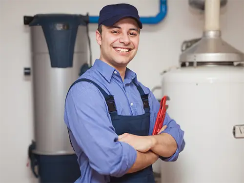 Smiling Mister Greenway technician standing by a water heater in Tennessee